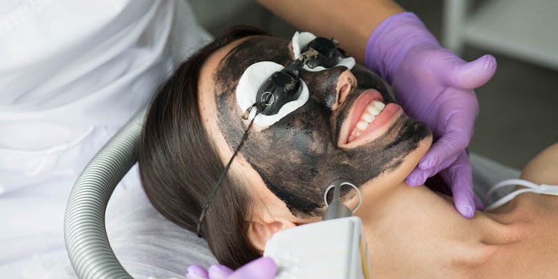 Cute woman gets a face peeling procedure in a beauty salon. Skin care Cute woman gets a face peeling procedure in a beauty salon. Skin care